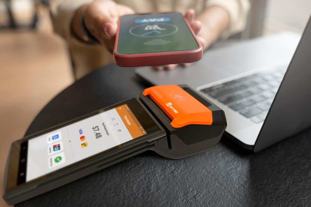 Close up of customer paying with their smartphone device on an OTT Pay Credit & Debit Card Machine