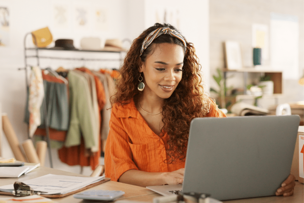 Small business owner on their laptop sitting at a workbench