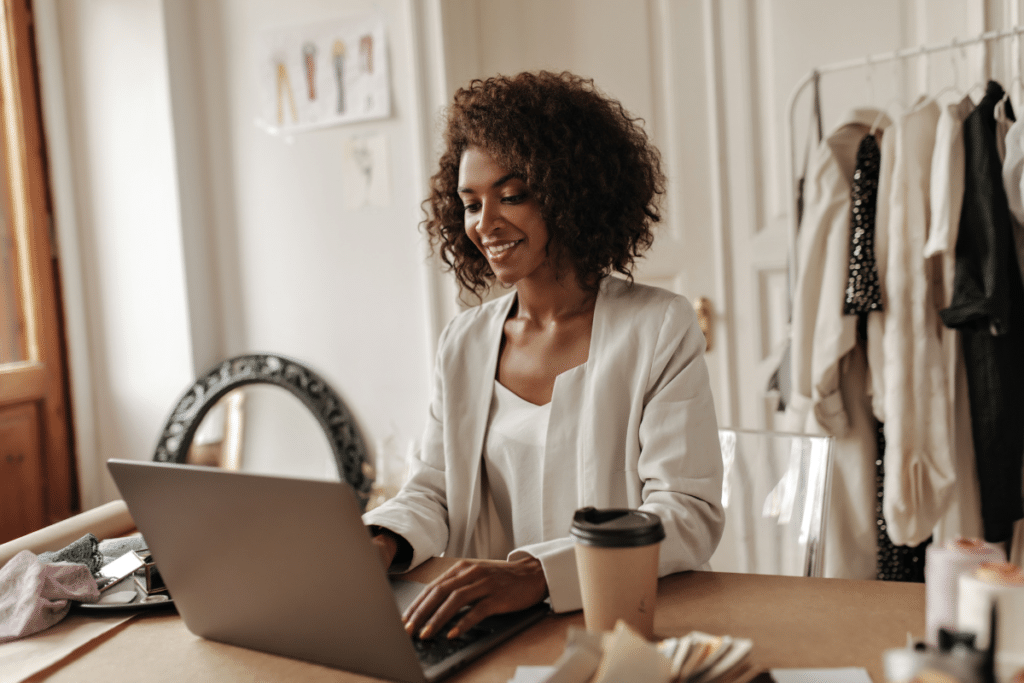 Woman sitting at her workbench, looking at her laptop